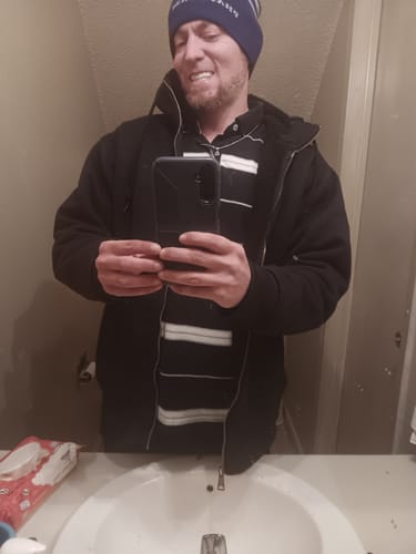 Customer taking a mirror selfie showing their natural teeth before getting Pop On Veneers.