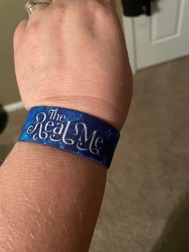 Customer wearing a blue Winter Wonders Add-On bracelet with the words 'The Real Me'.