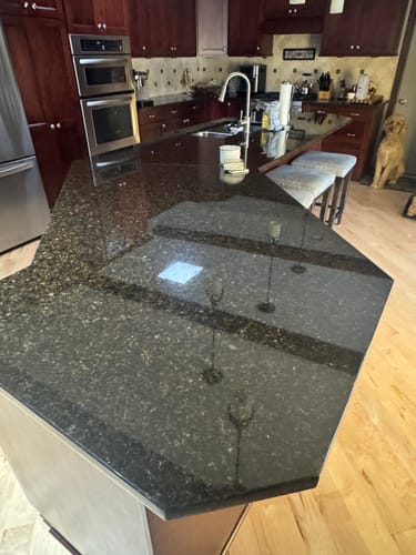 Reviewer's shiny, dark granite countertop after using the stone cleaner from the Trial Pack.