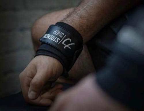 Close-up of a reviewer wearing the black Stealth Wrist Wrap from the Strength Kit.