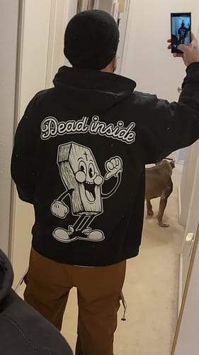 Reviewer in a mirror selfie showing the back of the black Dead Inside Pullover with its large cartoon graphic.