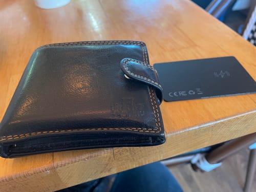 Customer's thin, black SPOTMINDERS Tracking Card next to a wallet on a table.