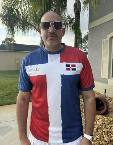 Close-up of a reviewer wearing the Dominican Republic Heritage Custom Football Jersey outdoors.