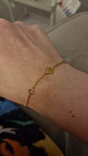 Close-up of a reviewer's wrist wearing the delicate gold Multi Clover Bracelet.