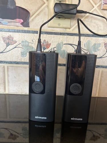 Customer's two black Airmoto devices charging side-by-side on a kitchen countertop.