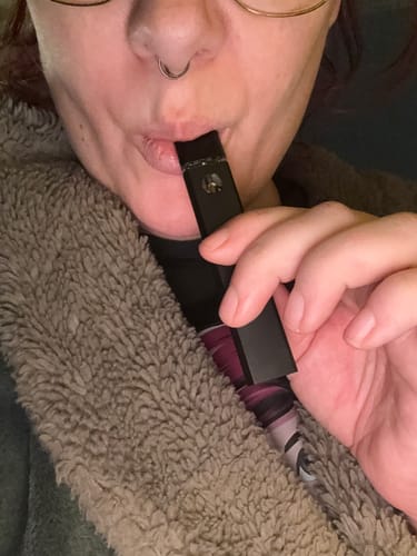 Close-up of a reviewer using the black 10-OH Superior LIVE RESIN VAPE pen.