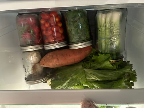 Customer's fresh vegetables stored in vacuum-sealed mason jars inside a refrigerator drawer.