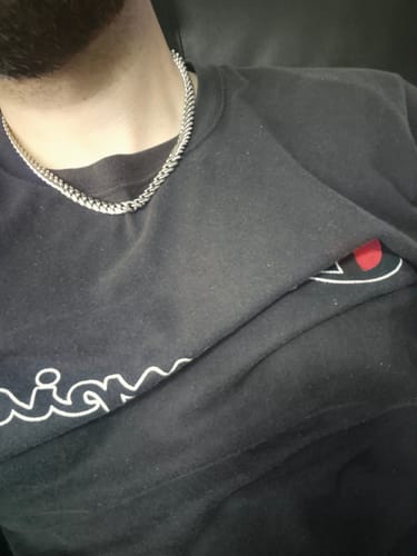 Primer plano de un cliente usando la Cadena Cuban Link de 8mm plateada sobre una camiseta negra.