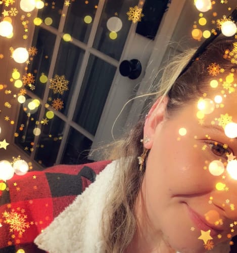 Close-up of a reviewer smiling while wearing the Crystal Lotus Waterfall Earrings.