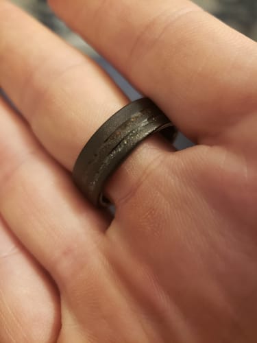 Close-up of a reviewer wearing the black Meteorsaur ring, showing its textured inlay.