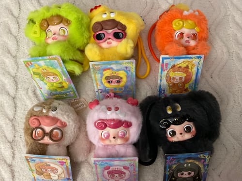 Reviewer's collection of six colorful, furry Q.Kid Emotional Hairy Monsters plush figures displayed with their cards.