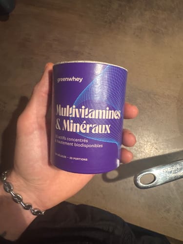 Client tenant dans sa main le pot de Multivitamines & Minéraux.