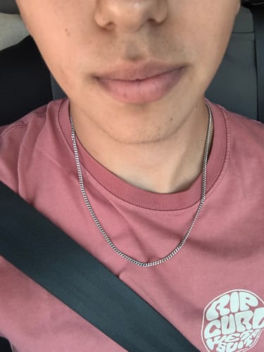 Primer plano de un cliente usando la Cadena Miami Cuban de 3 mm sobre una camiseta rosa.