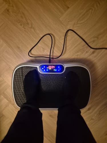 Anmelder, der står på vibrationstræneren med det digitale display tændt.