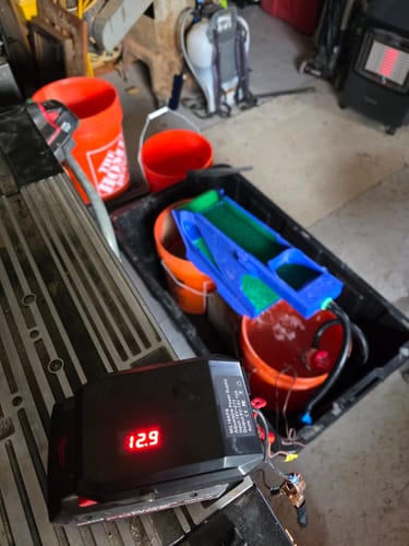 Customer's adjustable Step Down Converter powering a prospecting sluice pump, with the display showing 12.9V.