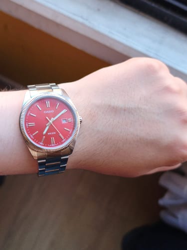 Reseñador mostrando el Reloj Casio Análogo con esfera roja en su muñeca.