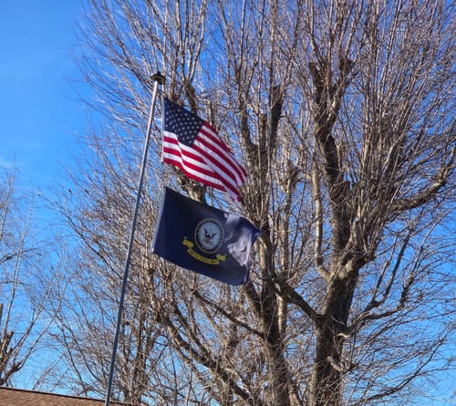 Customer's Ultra Heavy Duty American Flag flying outdoors on a flagpole against a clear blue sky.