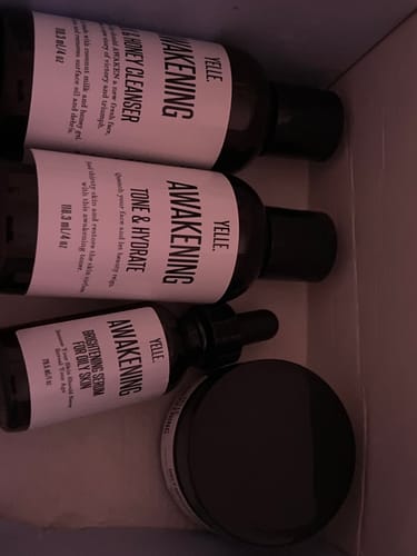 Customer's Awakening skincare products, including the Cleanser, Toner, and Brightening Serum, inside the shipping box.
