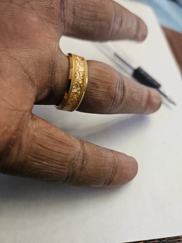 Customer's hand wearing the gold Aureum ring, showing its textured foil inlay.