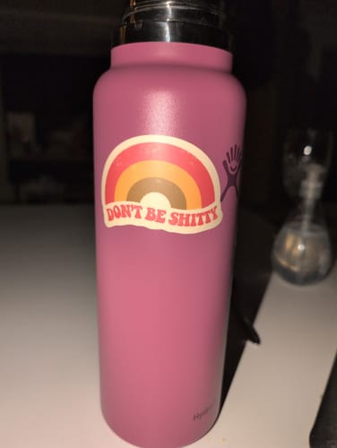 Reviewer's 'Don't Be Shitty Rainbow Sticker' applied to a pink water bottle.