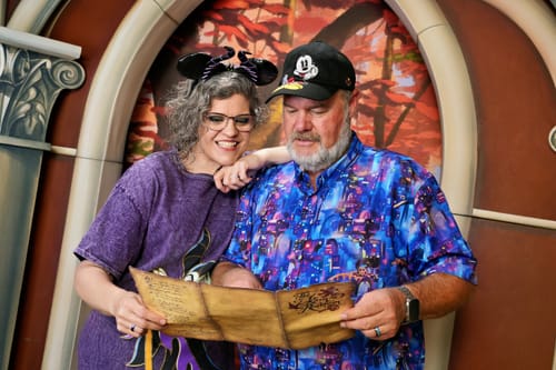 Customer wearing the vibrant Coco 'Land of the Dead' shirt while looking at a map with a companion at a park.