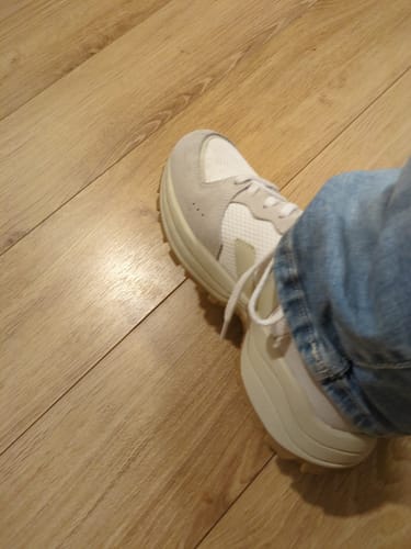 לקוח נועל את סניקרס ה-Veja Venturi II הבהירות עם הסוליה העבה.