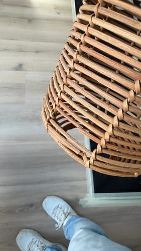 Klant toont de kapotte rotan Tanami hanglamp met een gat in de zijkant, wat de breekbaarheid illustreert.