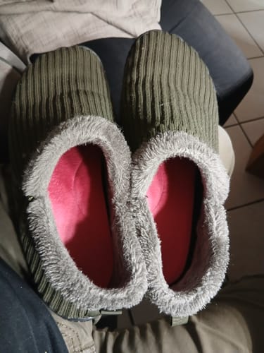 Ein Kunde zeigt die rosa Thermo-Einlegesohlen in einem Paar pelzgefütterter Schuhe.