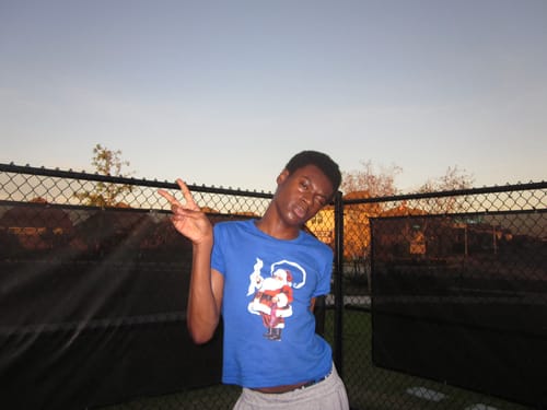 Reviewer posing outdoors in the blue Santa Baby Tee, showing its cropped fit.