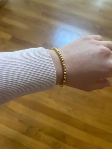 Reviewer wearing the delicate Niloya Beaded Gold Bracelet on their wrist over a light-colored sleeve.