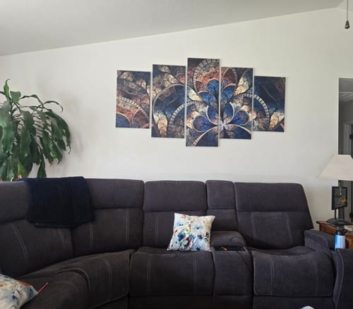 Customer's 5-panel Abstract Art canvas set hanging on a living room wall above a dark gray sectional sofa.
