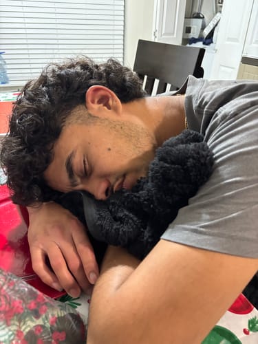 Customer sleeping on the plush, black teddy lining of their Geometric Jacquard Jacket.