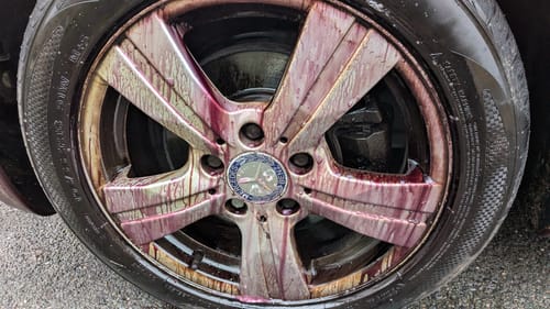 Customer shows Aurora fallout remover from the kit turning purple as it cleans a very dirty wheel.