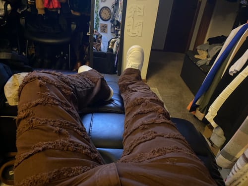 Customer's view while seated, wearing the brown Distressed Layered Twill Stacked Denim.