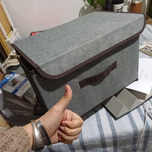 Cliente mostrando una caja de almacenamiento gris, totalmente armada, con el pulgar hacia arriba en señal de aprobación.