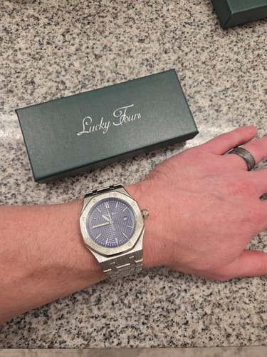 Customer's wrist showing the silver Lucky Fours Oceanus watch with its blue textured dial.