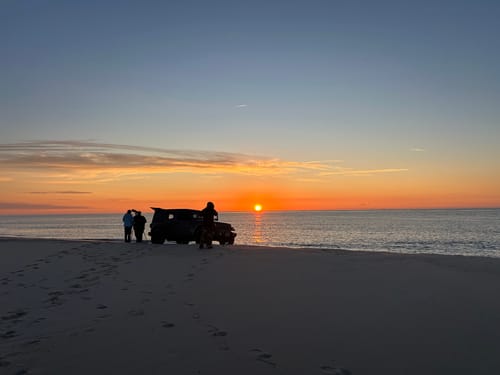 Reviewer on a cold beach at sunrise, kept warm and toasty by their Piper Pocket Leggings.