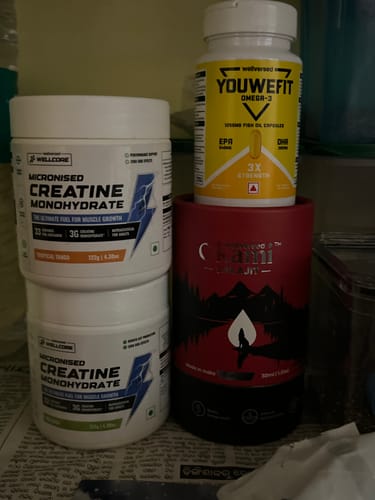 Customer's two tubs of Wellcore Micronised Creatine Monohydrate stacked on a shelf next to other supplements.