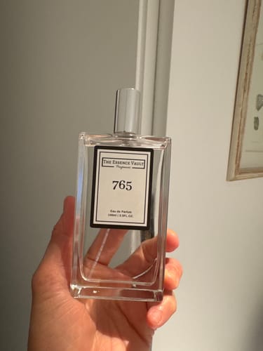 Customer holding a clear bottle of Inspired by Red Roses - 765 perfume in their hand.