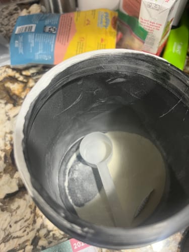 Reviewer's open jar of BGV Collagen Powder with a scoop resting on the powder inside.