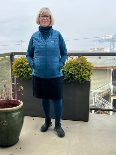 Reviewer wearing the Majolica Blue Neck Gaiter pulled up like a turtleneck, styled with a matching outfit outdoors.
