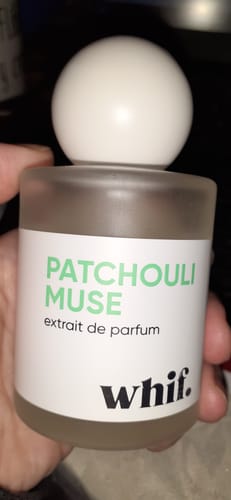 Customer holding the frosted glass bottle of Patchouli Muse extrait de parfum.