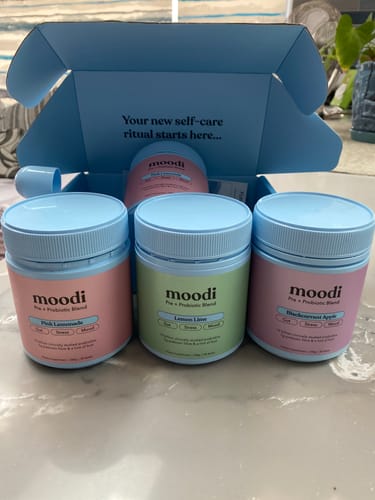 Customer's three colorful jars of the Classic Pre + Probiotic Bundle displayed in front of the open blue product box.