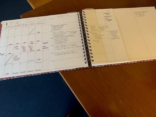 Customer's Nancy Planner laid open on a desk, showing the filled-out monthly and weekly horizontal layouts.