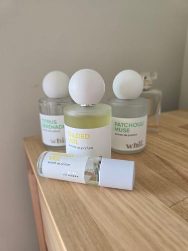 Customer's Gilded Veil perfume bottle and sample spray, part of a growing collection on a wooden surface.
