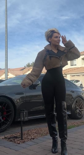 Reviewer standing outdoors wearing the light brown cropped Sherpa Jacket over a black outfit.