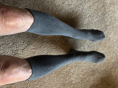 Reviewer wearing the dark grey Men's Alpaca Socks, which come up over the calf.