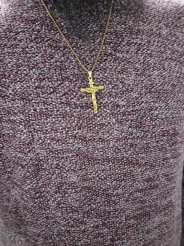 Customer wearing the gold-colored Christ Jewelry Crucifix Pendant Necklace against a speckled sweater.