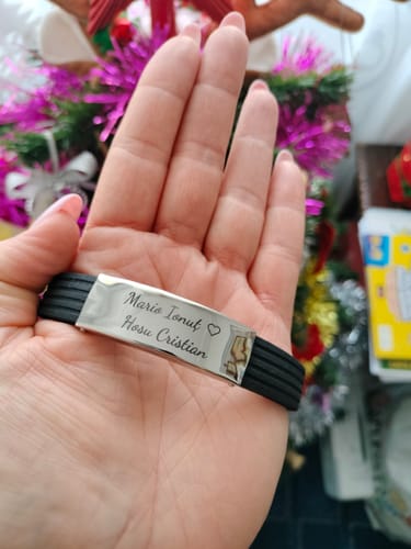 Customer's hand holding the personalized Atlas bracelet, showing the engraving on the stainless steel plate.