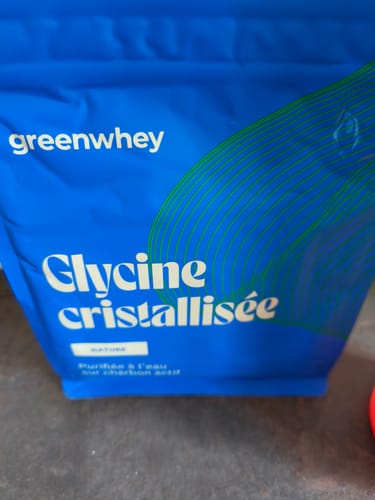 Photo d'un client montrant un gros plan du sachet bleu de Glycine cristallisée.